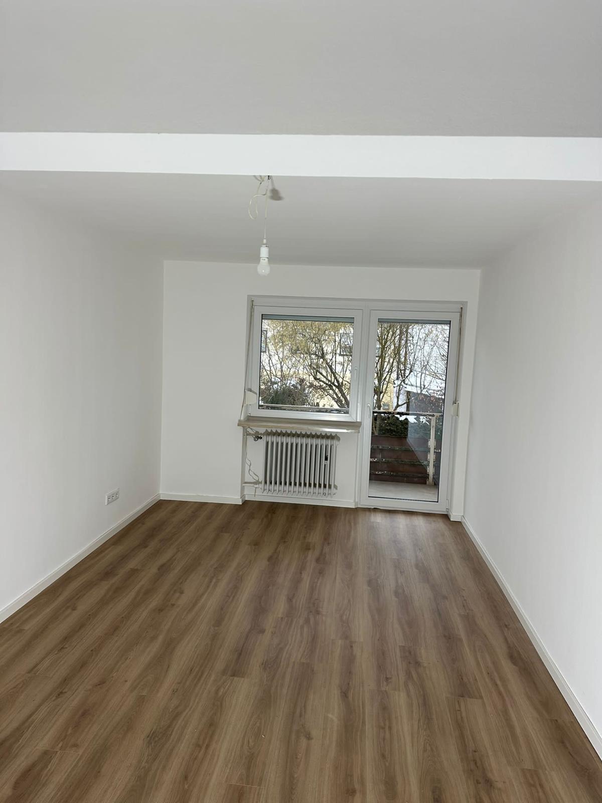 Wohnraum mit neu verlegtem Vinylboden in Holzoptik und frisch gestrichenen weißen Wänden – präzise ausgeführte Bodenarbeiten für modernes und gepflegtes Raumdesign.