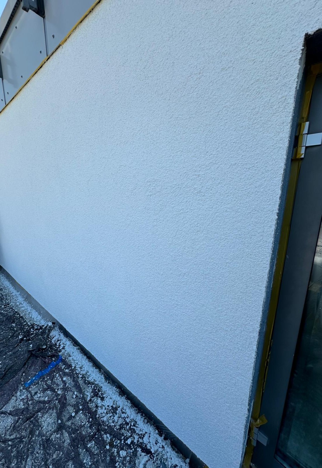 Frisch verputzte Außenwand mit sauber strukturierter Oberfläche – professionelle Fassadenarbeiten mit hochwertigem Putz für langlebigen Schutz und gleichmäßiges Finish.